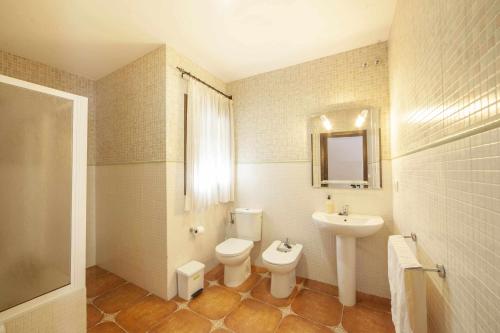 a bathroom with a toilet and a sink at Alojamientos Rurales Berrocal in Berrocal