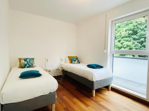 two beds in a room with a window at Luxury Green Penthouse Terrace&Parking - 117 in Luxembourg
