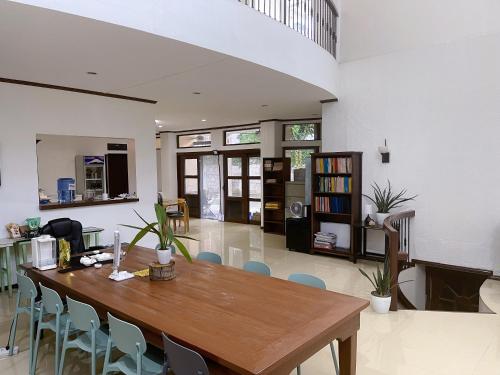 Best Inn Lahug في مدينة سيبو: غرفة معيشة مع طاولة وكراسي خشبية