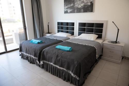 - 2 lits dans une chambre avec 2 serviettes bleues dans l'établissement Sunset apartment in Samarah Dead Sea resort, à Sowayma