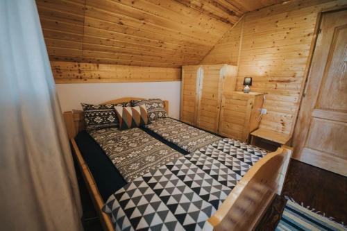 sypialnia z łóżkiem w drewnianym domku w obiekcie Cabana La Tiby w mieście Porumbacu de Sus