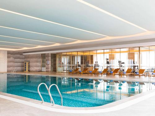 常熟的住宿－常熟理文鉑爾曼酒店，大楼内带椅子的游泳池
