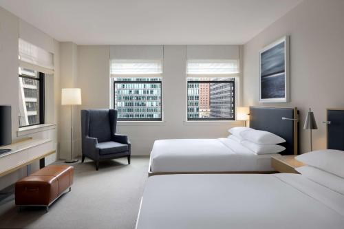 a hotel room with two beds and a chair at Hyatt Centric The Loop Chicago in Chicago