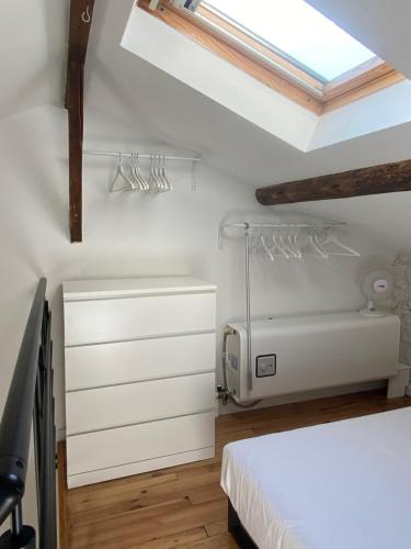 une chambre avec un lit blanc et une lucarne dans l'établissement La Carretariá - Intra•muros - Wifi, à Avignon