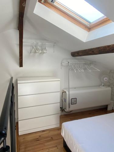 1 dormitorio con cama blanca y tragaluz en La Carretariá - Intra•muros - Wifi, en Aviñón