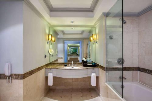 a bathroom with a tub and a sink and a shower at Wyndham Casablanca Jakarta in Jakarta