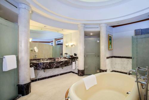 a large bathroom with a tub and a sink at Wyndham Casablanca Jakarta in Jakarta