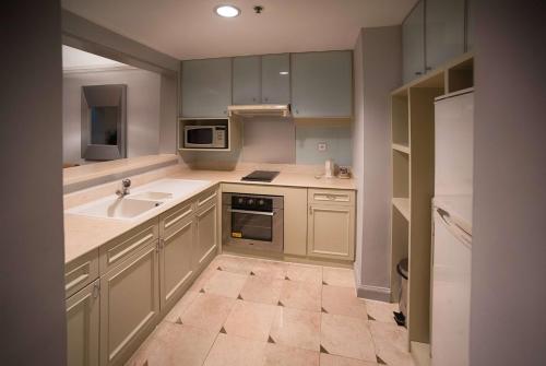 a kitchen with white cabinets and a sink at Wyndham Casablanca Jakarta in Jakarta