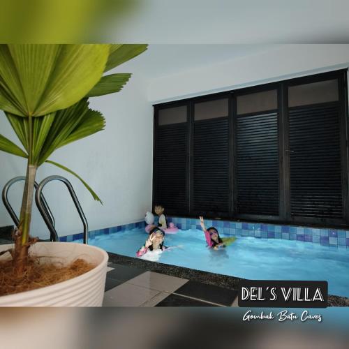 Dels Villa with private pool near UIA Batu Caves Gombak في بانيا إليجا: وجود طفلين يلعبون في المسبح