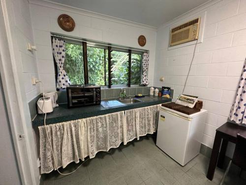 a kitchen with a counter with a sink and a window at Bamboo Cabin in Kuranda
