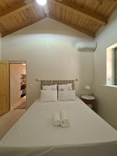 a bedroom with a white bed with two white towels on it at Kilada Holiday Home in Koilás