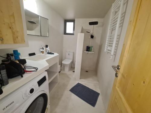 a bathroom with a washing machine and a sink at Kilada Holiday Home in Koilás