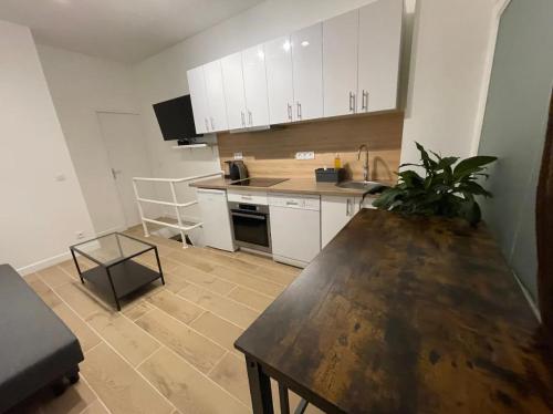 une cuisine avec des armoires blanches et une table en bois dans l'établissement Mathurin, à Paris