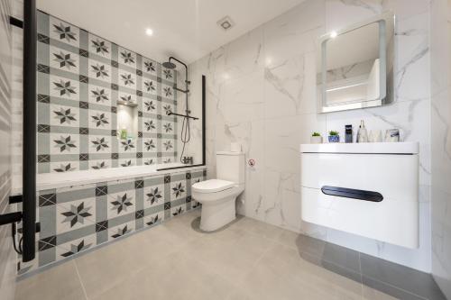 uma casa de banho branca com um WC e um lavatório em 8 - West London Brand New Loft em Londres