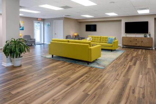 a lobby with two yellow couches and a flat screen tv at Atlantic Beach Resort, a Ramada by Wyndham in Atlantic Beach