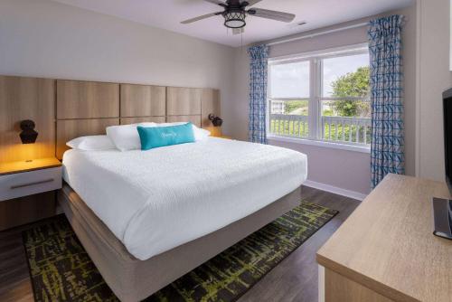 a bedroom with a large bed and a window at Atlantic Beach Resort, a Ramada by Wyndham in Atlantic Beach