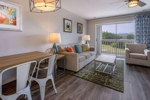 a living room with a couch and a table at Atlantic Beach Resort, a Ramada by Wyndham in Atlantic Beach