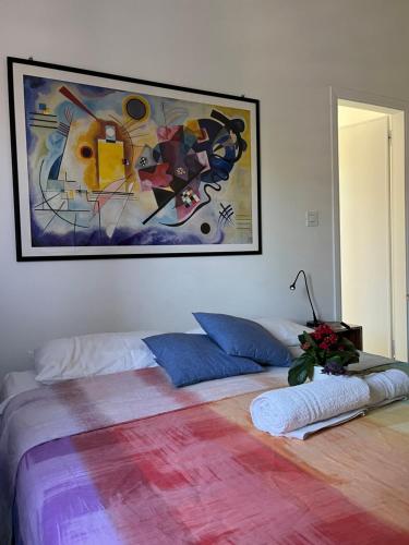 1 dormitorio con 1 cama con una pintura en la pared en Il Platano di Nathaly en Bari