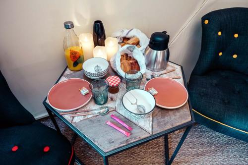 una mesa con platos y utensilios. en Les géodes du Domaine Jean Got, proche de Saint Emilion, en Lugaignac