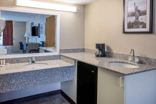 a hotel bathroom with two sinks and a mirror at Ramada by Wyndham Rome - Verona in Rome