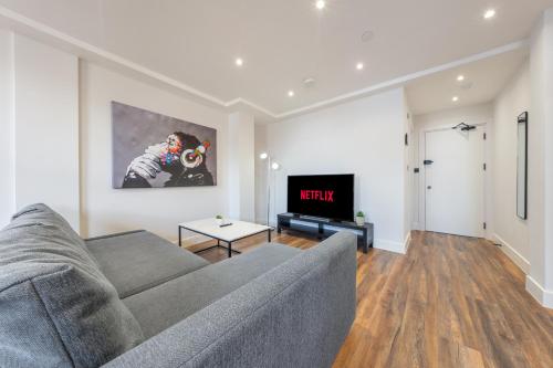 a living room with a couch and a tv at 6 - West London Brand New Loft in London