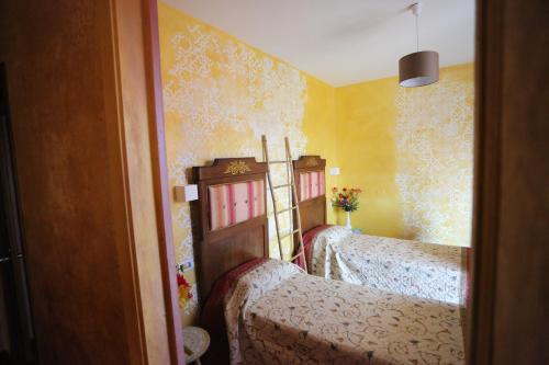 a bedroom with two beds and yellow walls at B & B L'almanacco in San Martino In Strada