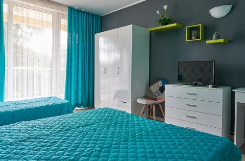 a bedroom with two beds and a television in it at Hotel Sea Star Приморско in Primorsko