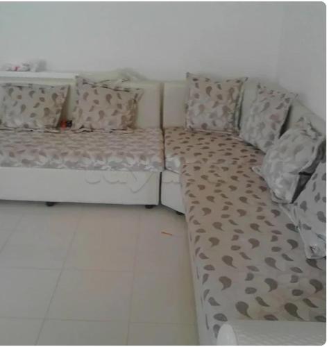 eine weiße Couch mit einer Decke und Kissen darauf in der Unterkunft Front of sea appartement hergla in Sousse