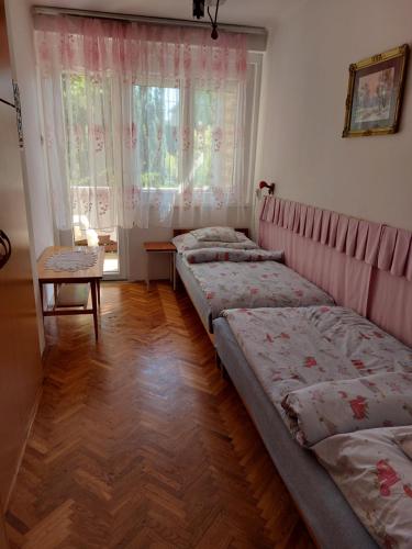 een kamer met 3 bedden en een raam bij Krisztina apartman in Balatonfüred
