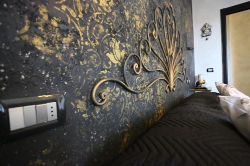a bedroom with a black and gold wall at B & B L'almanacco in San Martino In Strada