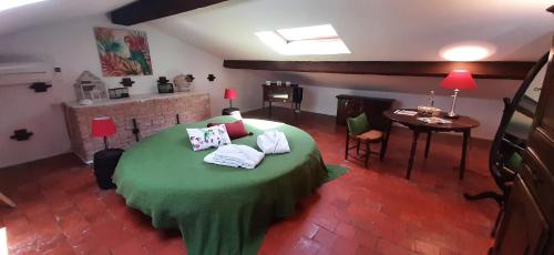 una camera da letto con un letto verde con sopra degli asciugamani di Bed and Breakfast La Grande Lauzade a Le Luc