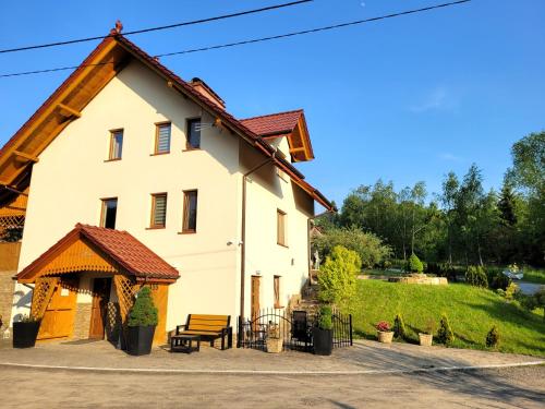 a large white house with a wooden roof at Willa Beskidzka in Myślenice