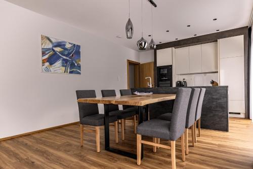 a kitchen and dining room with a wooden table and chairs at DAS MORITZ- Fine Living Apartments in Nauders