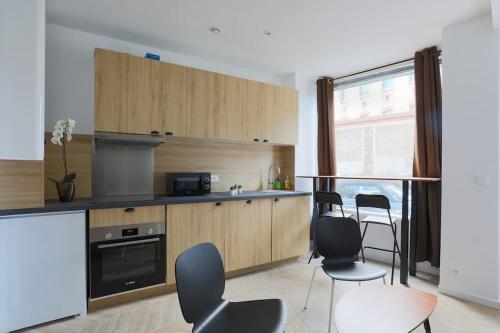 une cuisine avec des chaises, une table et une fenêtre dans l'établissement Très beau T3 proche RER Port Royal 6 pers, à Paris