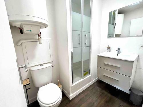een witte badkamer met een toilet en een wastafel bij T1bis avec terrasse et parking privés LE MIAMI in Perpignan