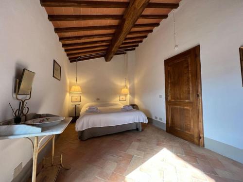 um quarto com uma cama e um lavatório num quarto em La Casa di Vignoni Alto em Bagno Vignoni