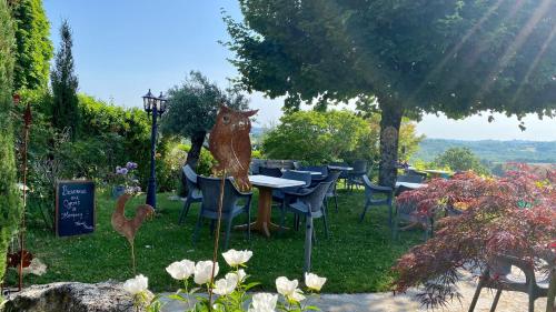 a statue of a squirrel sitting at a table in a garden at Hôtel Bien-Être Aux Cyprès de Marquay in Marquay