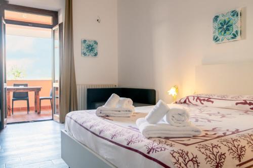a bedroom with two beds with towels on them at Piccola Locanda S'Ausentu in Uri