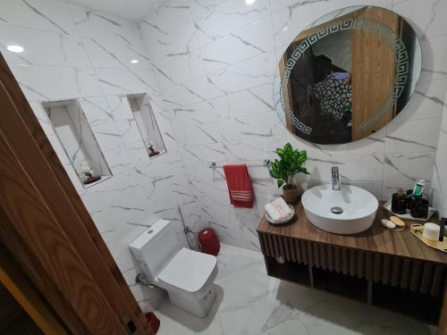 a bathroom with a toilet and a sink and a mirror at Villa de luxe in Imouzzer Kandar