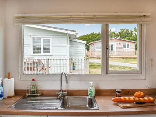 a kitchen counter with a sink and a window at Bows Pad in Gwithian