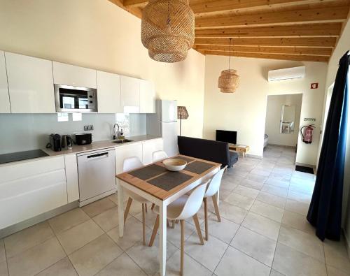 a kitchen and dining room with a table and chairs at Casa aOrta Studios in Faro