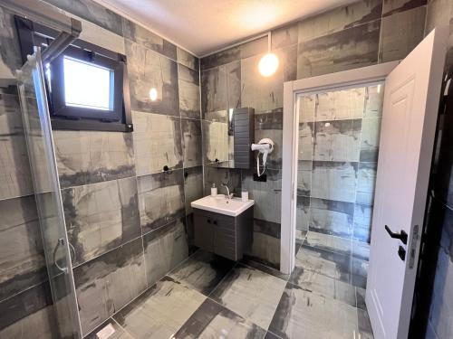 a bathroom with a sink and a toilet and a window at Noğa Suit Apart in Pazar