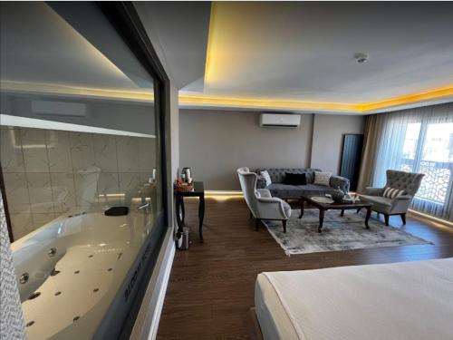 a hotel room with a tub and a bedroom at Bloom Suite Hotel in Keşan