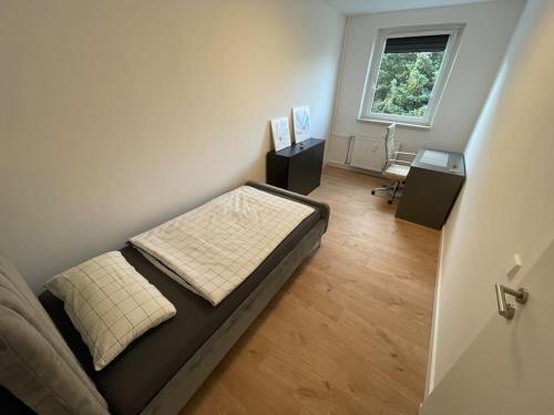 ein kleines Schlafzimmer mit einem Bett und einem Fenster in der Unterkunft Modernes Apartment/Nähe Zentrum in Magdeburg