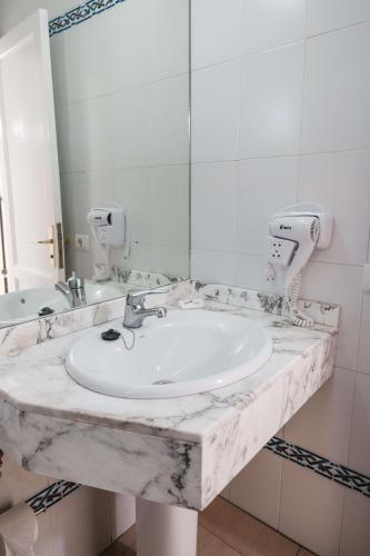 a bathroom with a sink and a mirror at Bungalows Parque Nogal in Maspalomas