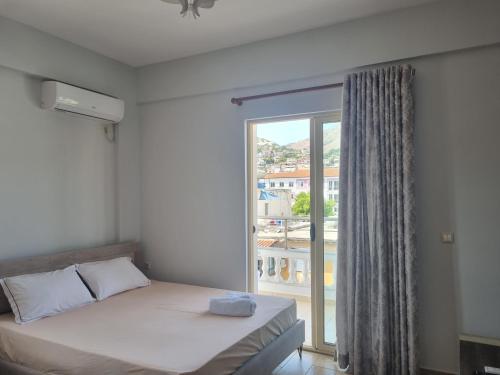 sypialnia z łóżkiem i dużym oknem w obiekcie Lea Apartament w Sarandzie