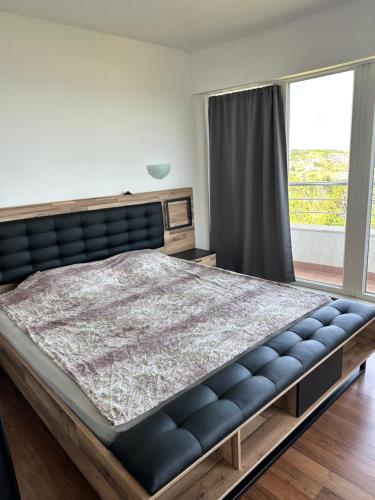 a bedroom with a large bed and a large window at Sun Gates Byala in Byala
