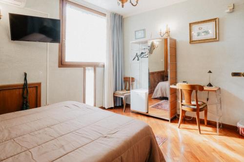 a bedroom with a bed and a desk and a window at Villa Luigi XVI in Taranto