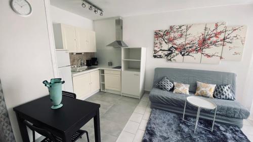 un salon avec un canapé et une table et une cuisine dans l'établissement Cosy 3pièces à 5min de la plage, à Cannes