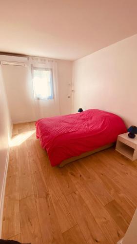 - une chambre avec un lit rouge et du parquet dans l'établissement Cosy 3pièces à 5min de la plage, à Cannes